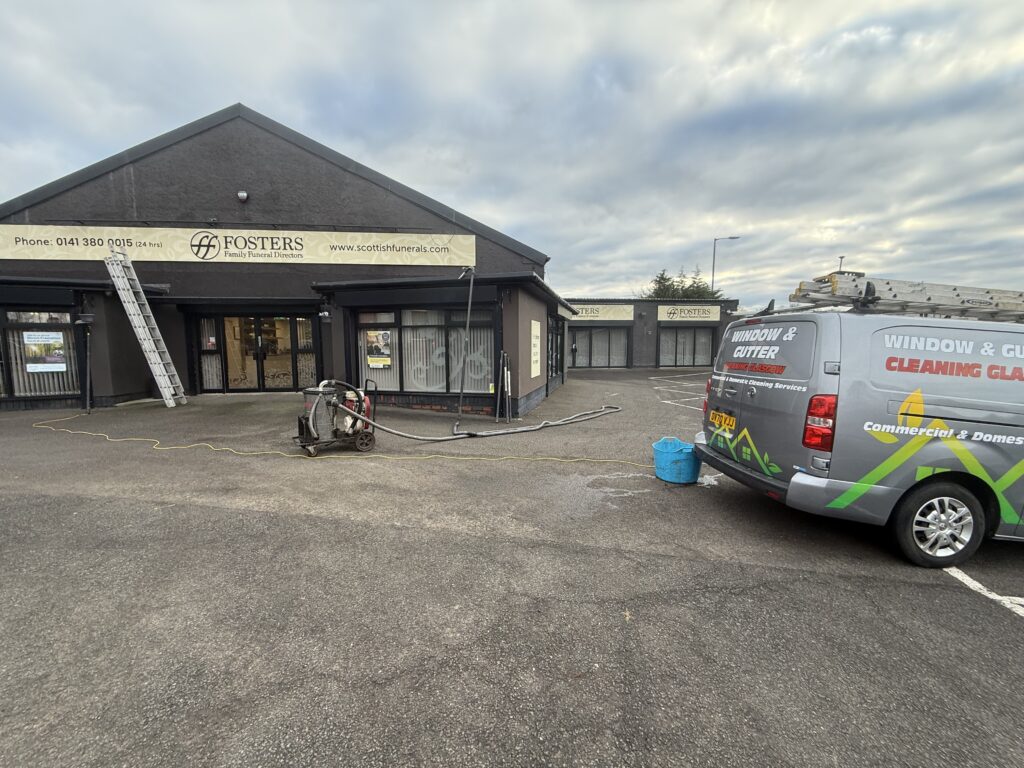 Exterior of a community center with a parked van and scooter in front.