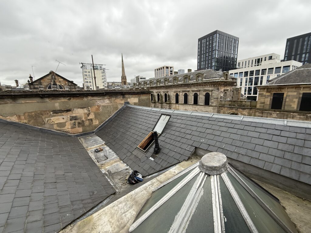 View of rooftops with chimney pots in an urban setting.